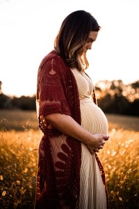 pregnant woman holding hands at belly