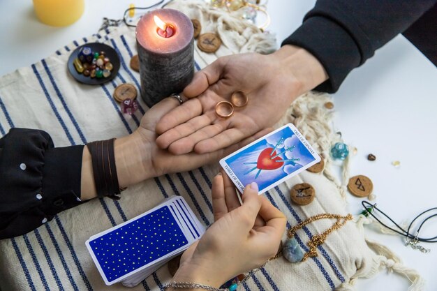 Woman fortune teller reading tarot cards for a man, selective focus spiritual scene.